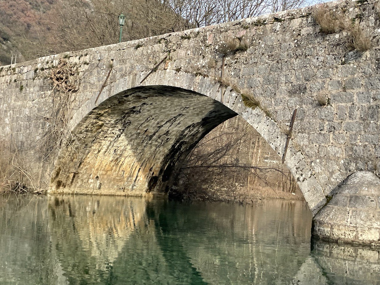 Close-up of Danilo's Bridge arch reflected in the river