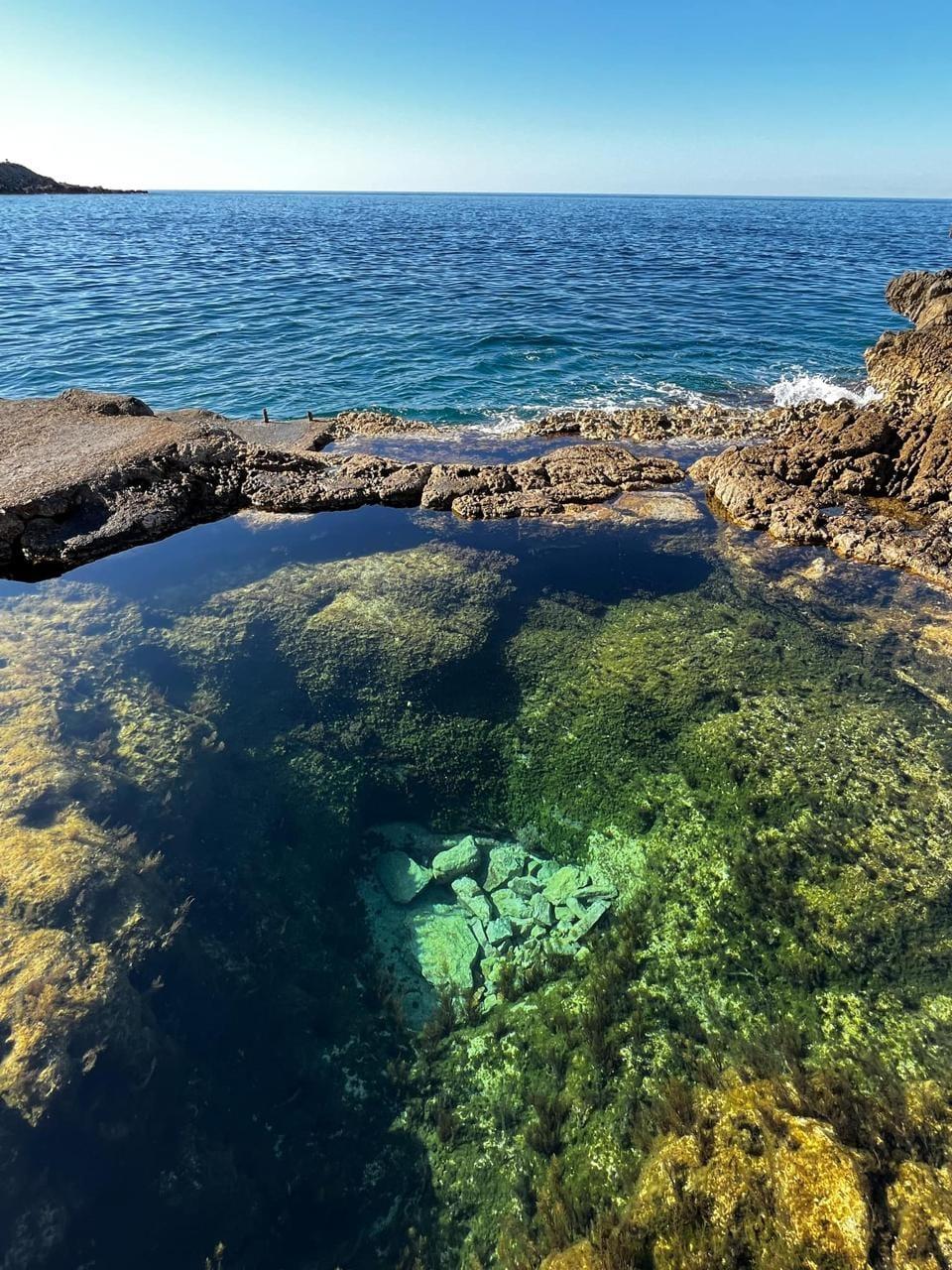 Clear rock pool meeting the sea